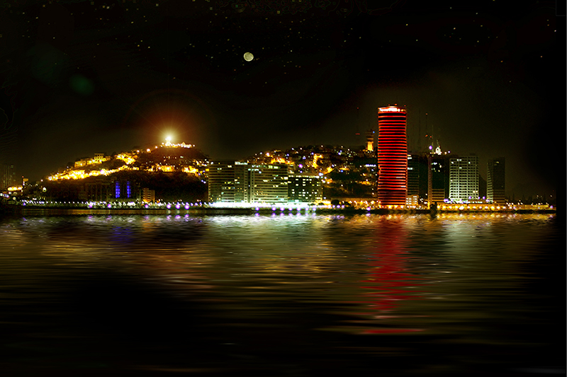 Illuminated city skyline featuring a red tower and bright hill reflecting on dark water under a night sky